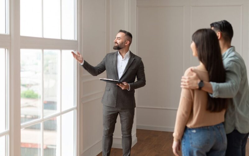 Real estate agent tours a couple around a home listing