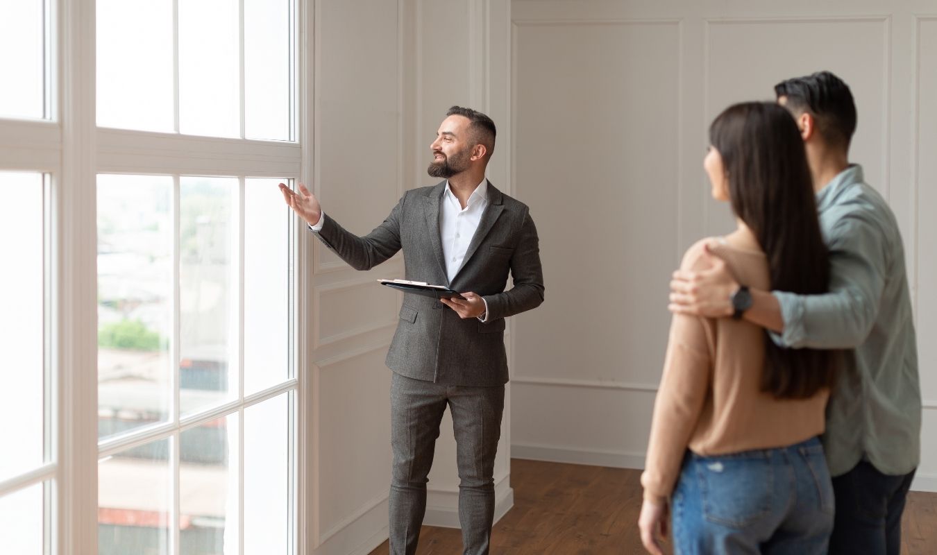 Real estate agent tours a couple around a home listing